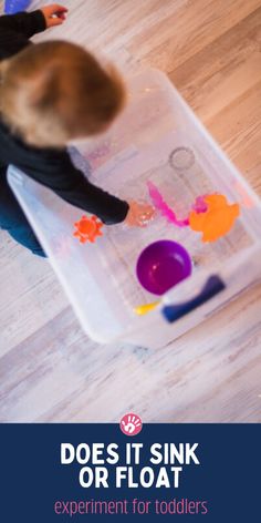 a young child is playing with paints on a plastic tray that says does it sink or float? experiment for toddlers