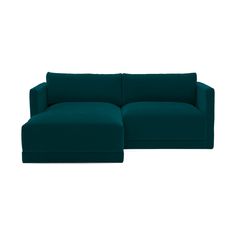 a large blue couch sitting on top of a white floor next to a green ottoman