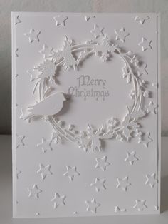 a white christmas card with snowflakes and stars on the bottom, in front of a