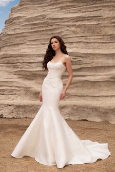 a woman in a white wedding dress posing for the camera with her hands on her hips