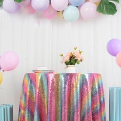 there is a table that has some balloons and flowers on it, along with other decorations