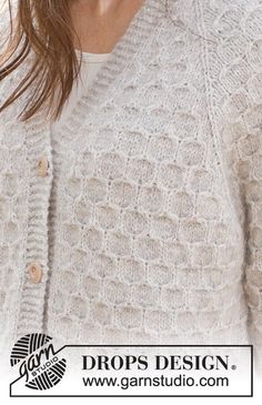 a close up of a person wearing a white cardigan sweater with buttons on the front