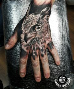 a hand with an owl tattoo on it