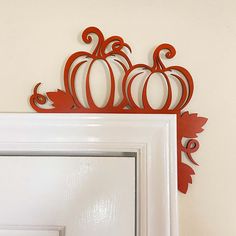 a white door with an orange pumpkin cutout on the front and back of it