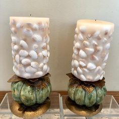 two white candles sitting on top of each other