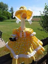 a stuffed animal wearing a yellow dress and hat