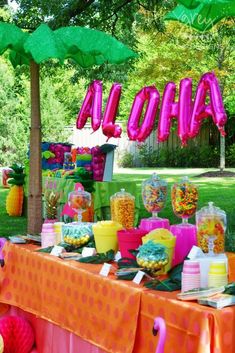 the table is set up with candy and decorations for an outdoor birthday party or baby shower