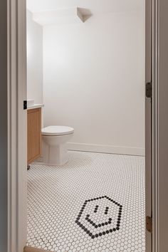 a bathroom with a toilet, sink and tiled flooring in it's doorway