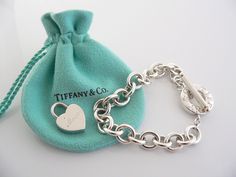 Offered for sale is a wonderful and rare Tiffany and Co. Sterling Silver "Mom" Heart Padlock bracelet. The piece is made from substantial and bright Tiffany silver, and yet retains a very feminine feel to it. Attached to its very substantial Tiffany & Co Silver Toggle charm bracelet is a Heart padlock charm with "Mom" written in beautiful script. The"Mom" padlock charm opens and closes and thus can be used as a charm on a necklace or as part of another charm bracelet! Super versatile piece! Luxury Sterling Silver Heart Bracelet For Gift, Luxury Heart Charm Bracelet Gift, Elegant Valentine's Day Bracelets With Toggle Clasp, Elegant Heart Bracelet With Toggle Clasp For Gift, Heart-shaped Jewelry Gift With Clasp, Heart-shaped Jewelry With Clasp For Gifts, Valentine's Day Gift Bracelet With Toggle Clasp, Valentine's Day Heart Bracelet With Toggle Clasp, Valentine's Day Gift Heart Bracelet With Toggle Clasp