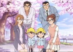 the family is posing for a picture in front of cherry blossom trees