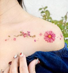 a woman's shoulder with pink flowers on it