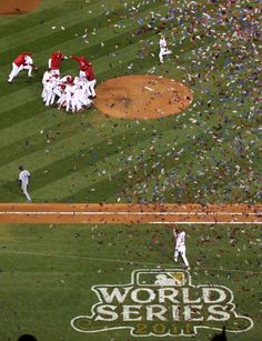 a baseball game with confetti thrown in the air and players on the field