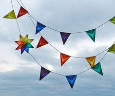 colorful kites are flying in the sky on a cloudy day