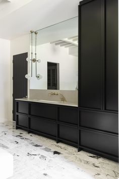 a large bathroom with black cabinets and marble flooring on the walls is pictured in this image