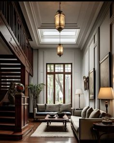 a living room filled with lots of furniture next to a wooden stair case in front of a window