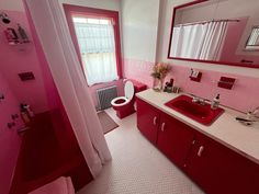 a bathroom with pink walls and white flooring