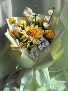 a bouquet of flowers is wrapped in white paper