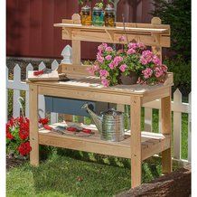 a potting bench with flowers and gardening tools