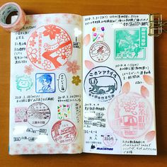 an open notebook with japanese stickers on it and a roll of tape next to it