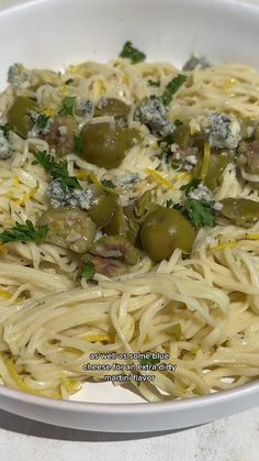 a white bowl filled with pasta and olives