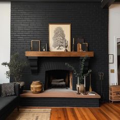 a living room with a black brick fireplace and wooden flooring on the hardwood floors