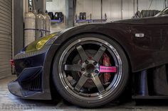 the front wheel of a sports car parked in a garage