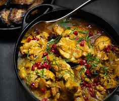 a pan filled with chicken and vegetables on top of a table