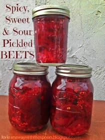 three jars filled with pickled beets sitting on top of a table