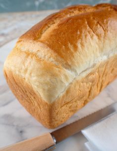 a loaf of bread sitting on top of a cutting board with a knife next to it