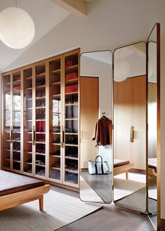 a bedroom with mirrored closet doors and clothes on display