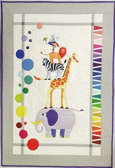 a quilted wall hanging with an elephant, giraffe and zebra on it