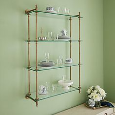 the shelves are filled with glassware and vases on top of each shelf in this room