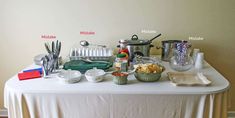 the table is covered with dishes, utensils and other kitchen items that are on it