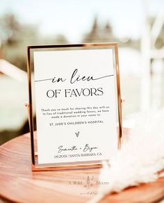 a close up of a menu on a wooden table with a white feather in the foreground