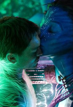 a man and woman kissing each other in front of a green background with glowing lights