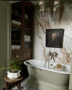 an old fashioned bathtub in the corner of a bathroom with marble walls and floor