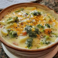 a bowl filled with broccoli and cheese on top of a table