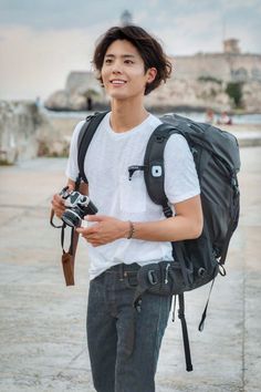 a young man with a camera and backpack