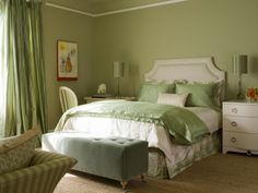 a bedroom with green walls and white furniture