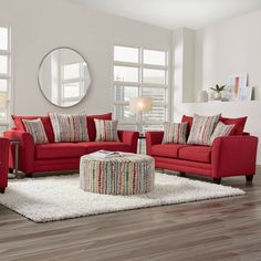 a living room with red couches and white rugs