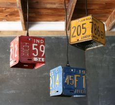 three boxes are hanging from the ceiling with tags attached to them and numbers on each box