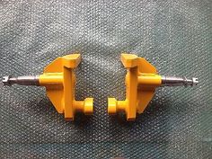 two yellow handles on the back of a pair of skateboard wheels, one with an axle