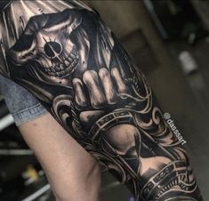 a man's arm with a skull and clock tattoo on the left side of his arm