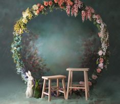 two wooden stools in front of a floral arch