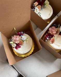 three cakes in boxes with flowers on them