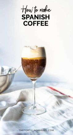 a glass filled with coffee sitting on top of a table