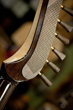 the back end of a wooden chair with metal handles and wood grained seat cushions