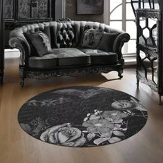 a black and white photo of a couch in a living room with wooden flooring