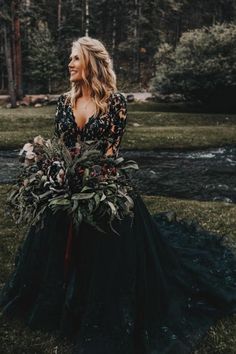 a woman in a black dress standing on grass