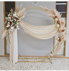 a wedding arch decorated with flowers and feathers